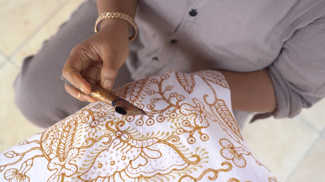 The technique of making hand-drawn batik using a canting tool. This craftsman is making batik typical of Giriloyo Bantul Yogyakarta.
