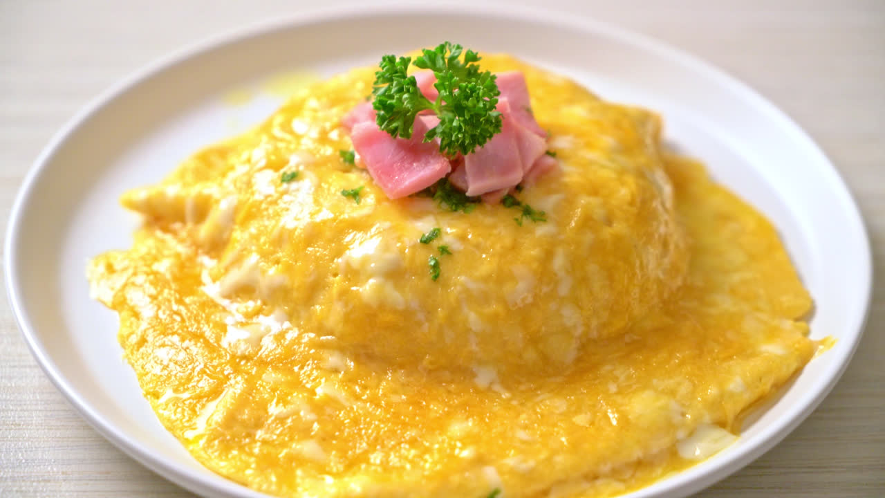 라이스에 햄을 얹은 크리미 오믈렛 또는 햄과 부드러운 오믈렛을 얹은 라이스