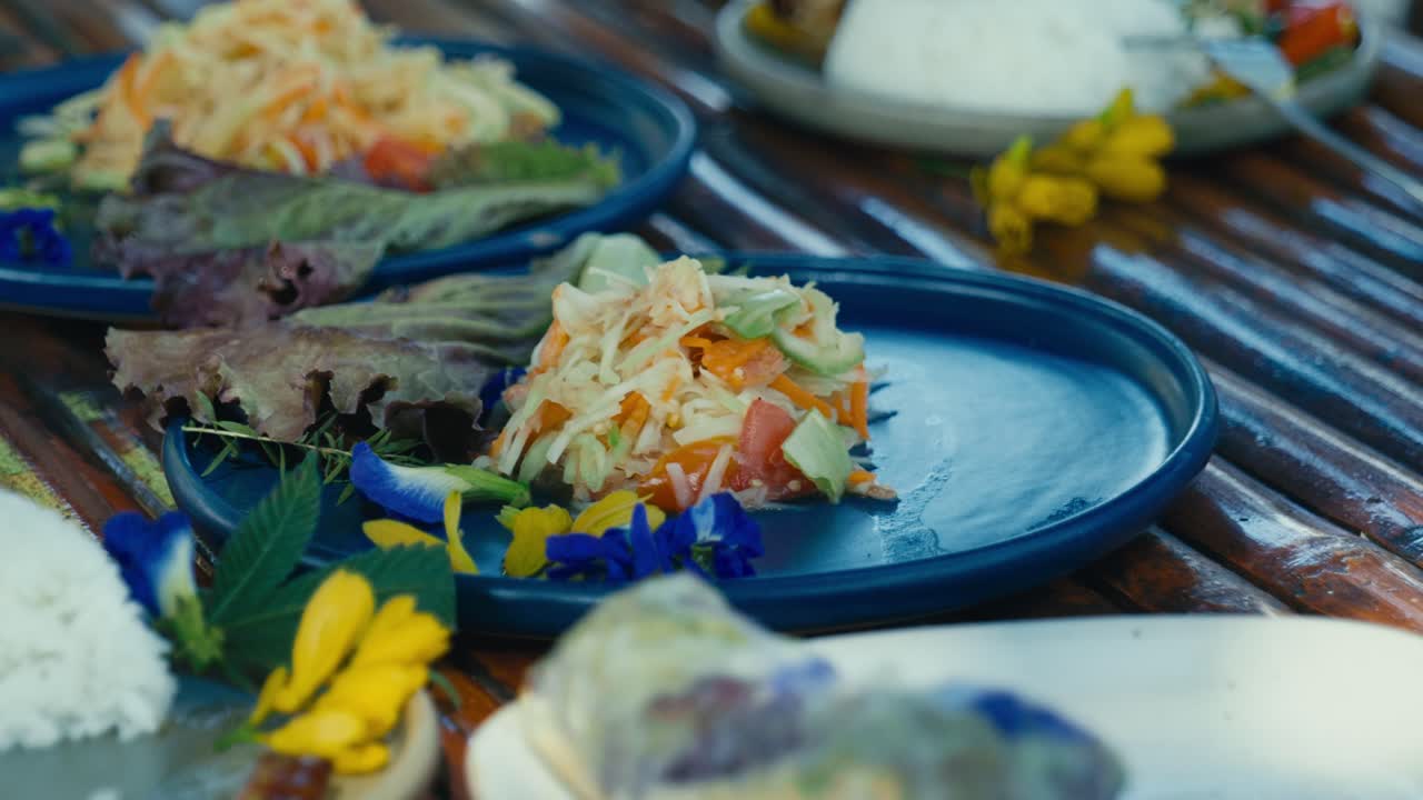 Un piatto di insalata di papaya thailandese, nota anche come som tam, con papaya fresca grattugiata, peperoncini e verdure in un classico piatto thailandese.
