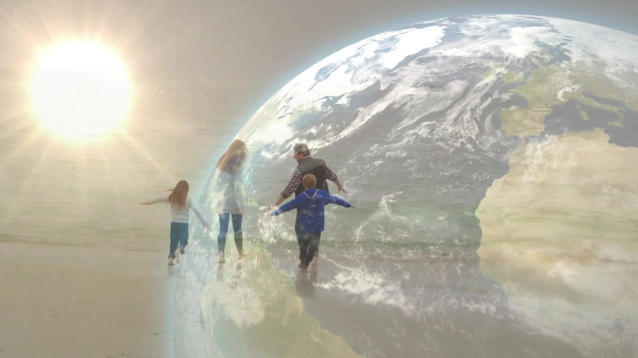 Familia de cuatro caminando y chapoteando en la arena mojada con la marea baja, vistiendo chaquetas, con superposición de globo