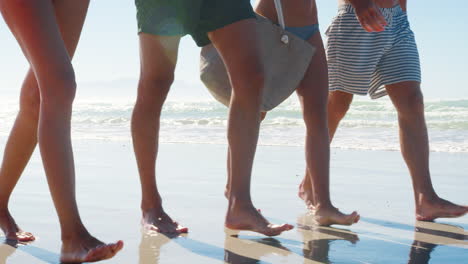 Nahaufnahme-Der-Beine-Eines-Freundes,-Der-Im-Strandurlaub-Entlang-Der-Küste-Spaziert