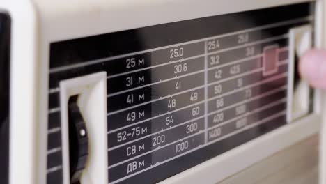 a female fingers tuning the frequency on an old vintage analog receiver. 4k