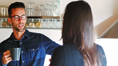 una pareja interactuando entre sí mientras toman café.