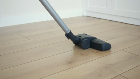 closeup of a vacuum cleaner cleaning a wood floor