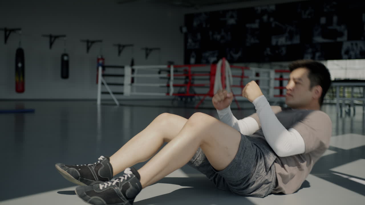 Man Doing Sit-ups in a Boxing Gym