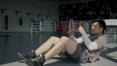 man doing sit-ups in a boxing gym