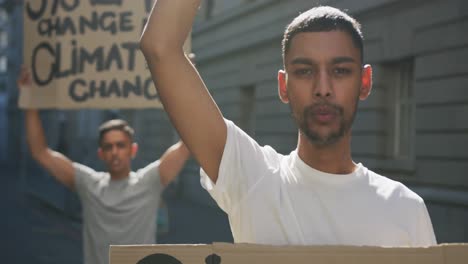 dos hombres de raza mixta en una marcha de protesta con pancartas levantando las manos y gritando