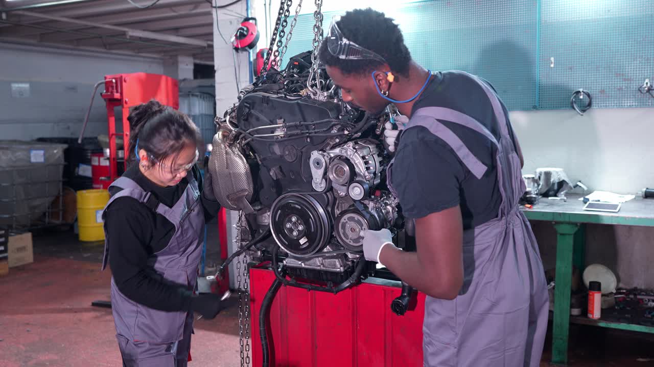 Mechanics working on an engine in a repair shop