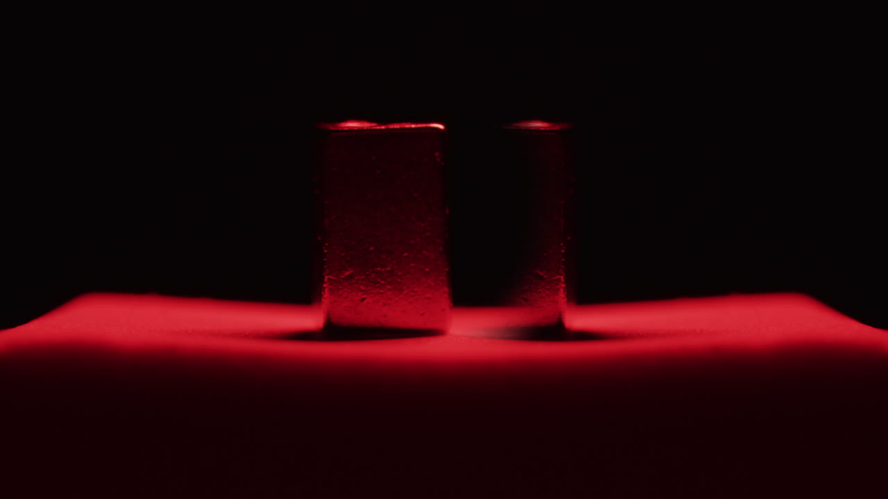 Two Square Metal Objects Under Red Light