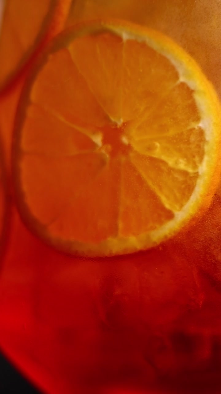 Primo piano di fette d'arancia in un cocktail Aperol Spritz ghiacciato