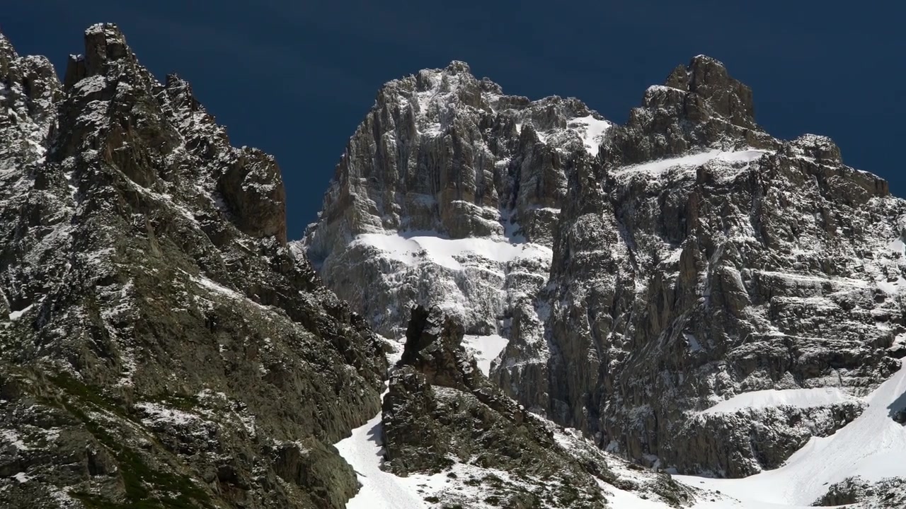 Maestose cime montuose innevate sotto un cielo azzurro limpido