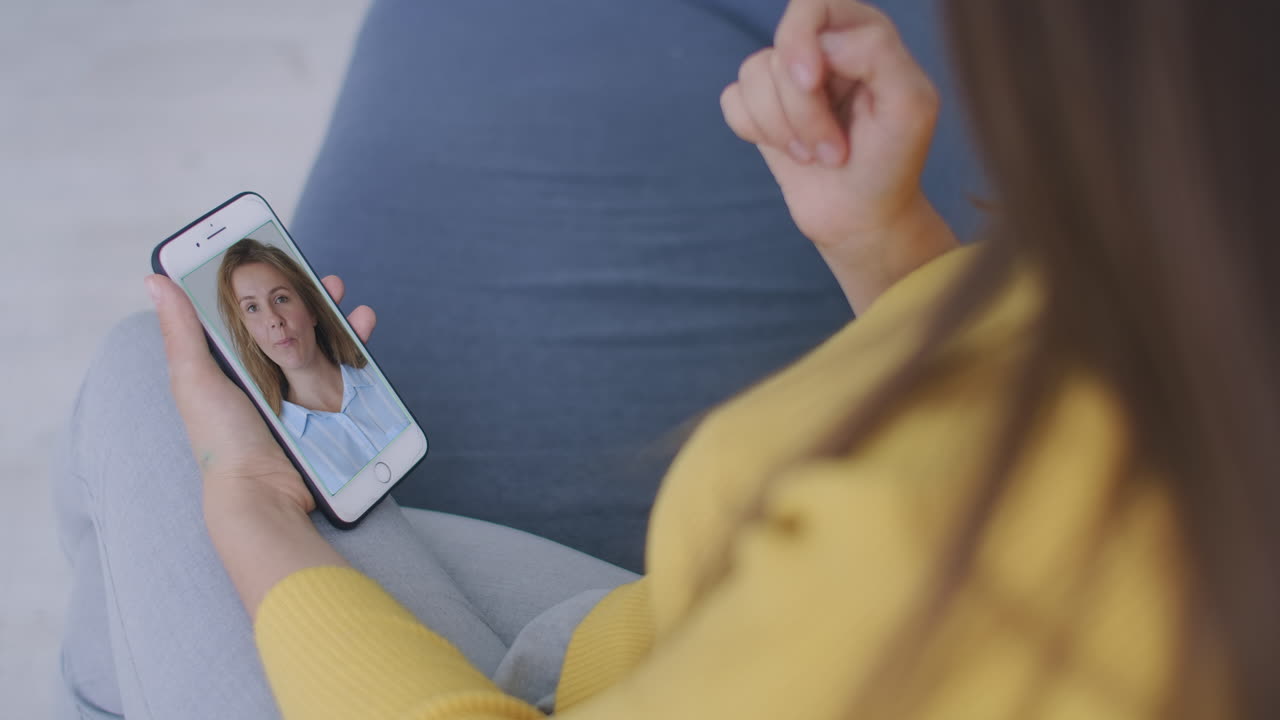 mujer joven chateando en video con un amigo usando un teléfono inteligente saludando con la mano compartiendo durante el autoaislamiento mejores amigos disfrutando de la comunicación a larga distancia