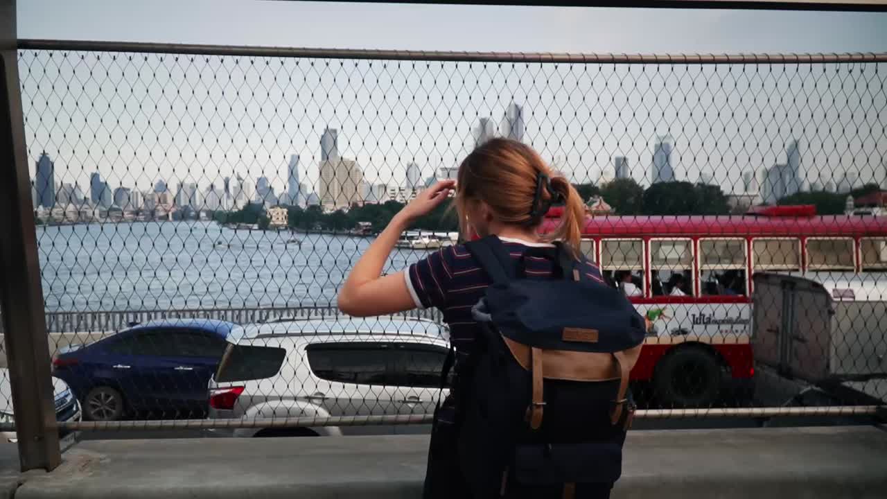 mujer mochilera disfrutando de las vistas de la ciudad desde el chao phraya sky park en bangkok, tailandia