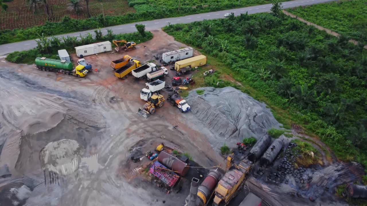 Beautiful aerial of a large sand quarry surrounded by tropical vegetation in rural Nigeria, Africa