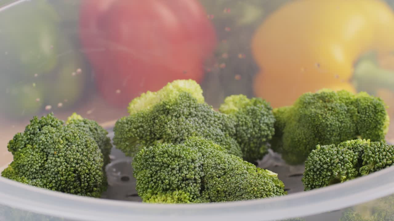 Mixed vegetables, carrots, broccoli, and cauliflower in a food double boiler steamer basket in a stainless steel pot, healthy diet cooking method preserving minerals, vitamins and flavor