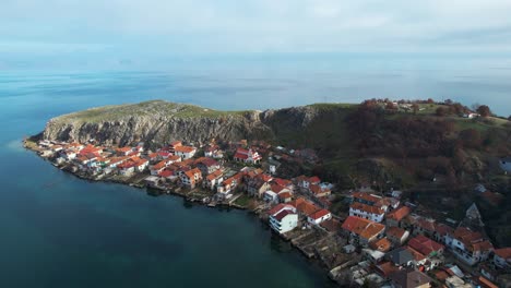 península de lin cerca de pogradec con colinas rocosas y casas de pueblo construidas a orillas del lago ohrid