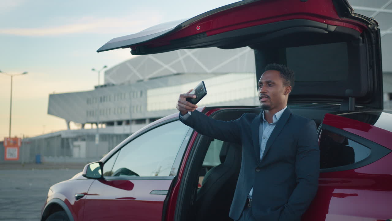 hombre tomando una selfie por un suv rojo