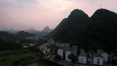 yangshuo at sunrise with misty mountains and a small town nestled below, china