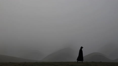solitary figure in a foggy mountain landscape