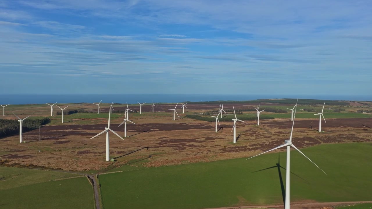 Imagens de drone capturando inúmeras turbinas eólicas gerando eletricidade limpa e sustentável em um parque eólico na paisagem rural inglesa.