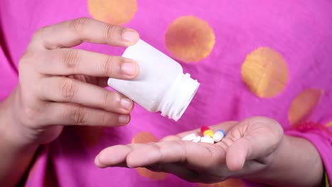 person taking pills from a bottle