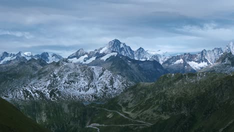 Impresionante-Vista-Panorámica-De-La-Cordillera-De-Los-Alpes-Suizos-Cubiertos-De-Nieve-Y-La-Carretera-Sinuosa.