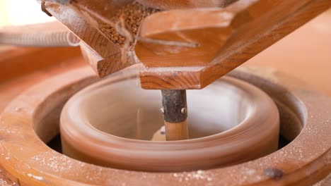 closeup of stone mill grinding wheat grains