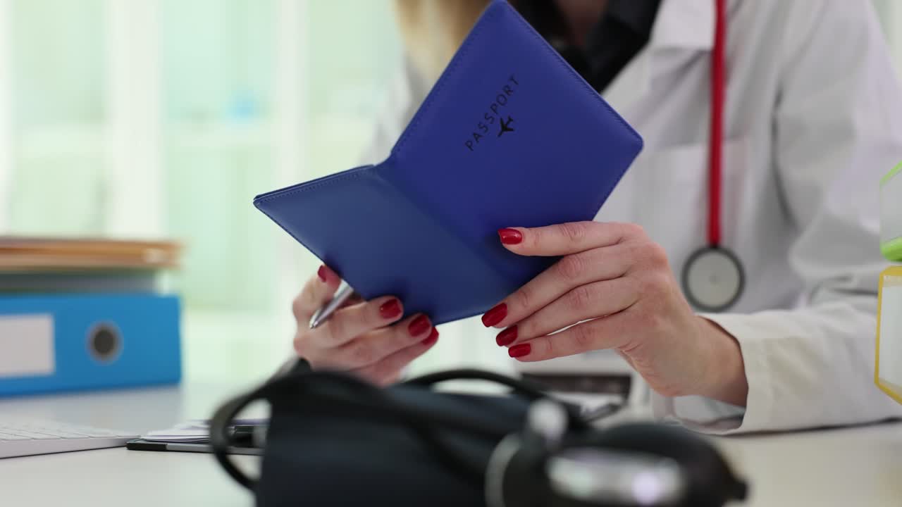 A medical professional holding a passport and writing
