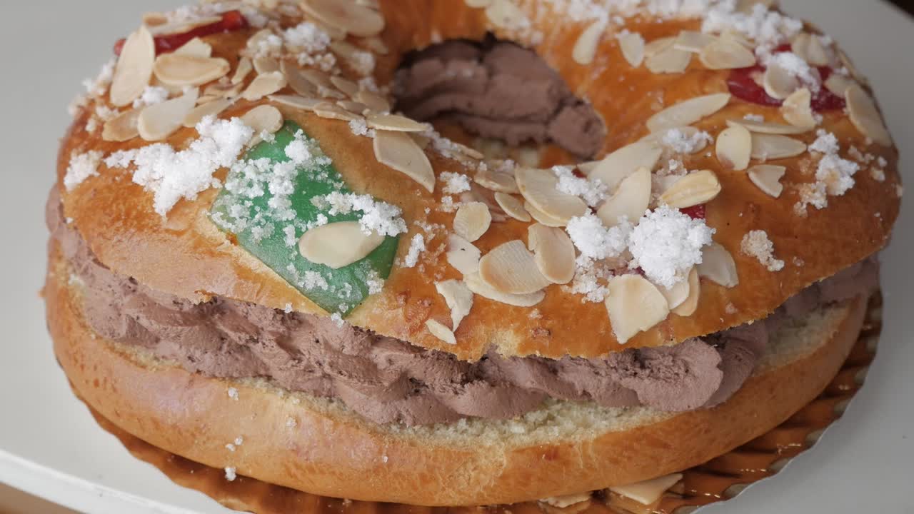 un roscón de reyes tradicional con crema, almendras, azúcar y frutas confitadas
