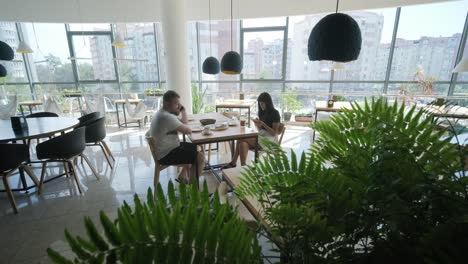 couple having lunch at a modern cafe with city view