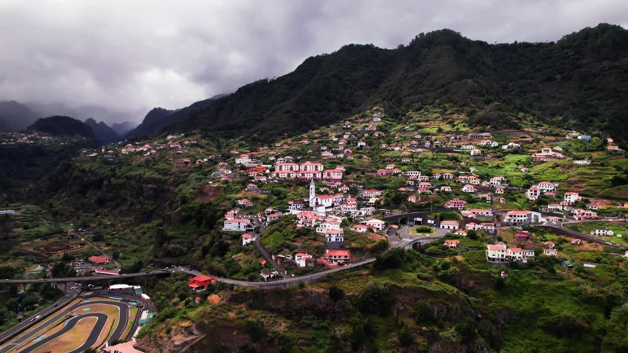 paisaje aéreo de una ciudad en la ladera de una montaña volcánica verde, madeira