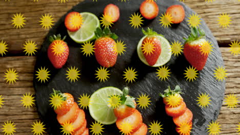 fresas y rebanadas de lima en pizarra con animación amarilla de estallido de estrellas
