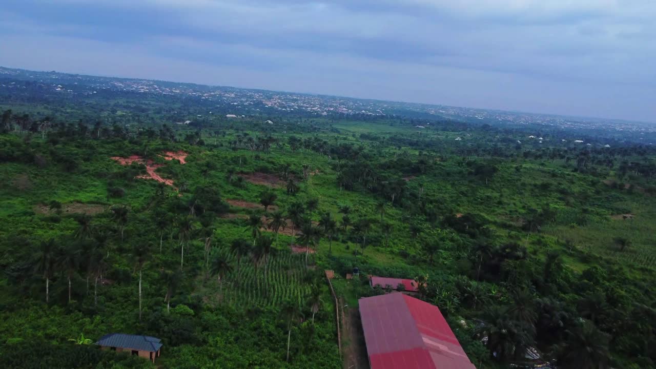 Beautiful aerial of a large farm surrounded by stunning lush and green nature in the countryside of Nigeria, Africa