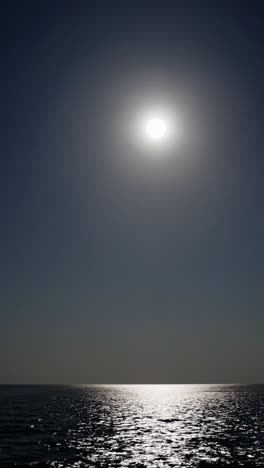 a serene seascape video with a low-angle view capturing the moon's reflection on the water