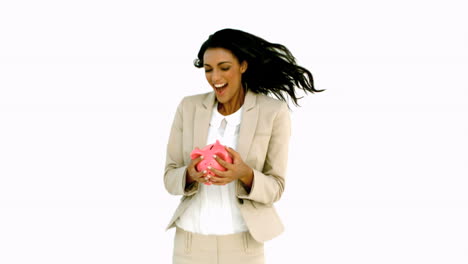 businesswoman jumping and holding piggy bank