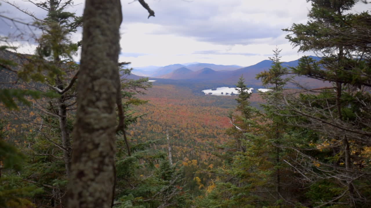 hermosa vista otoñal de las montañas adirondack con colores rojos y amarillos vibrantes que llenan el valle de abajo