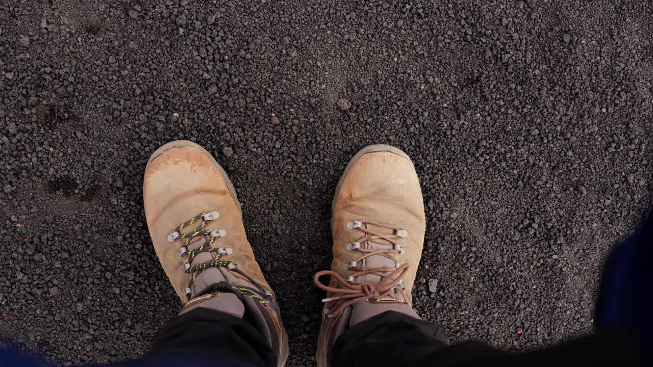 Hiking boots on volcanic soil, exploring Etna's rugged terrain