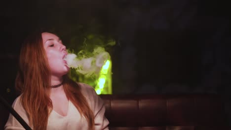 mujer fumando narguile en un club nocturno