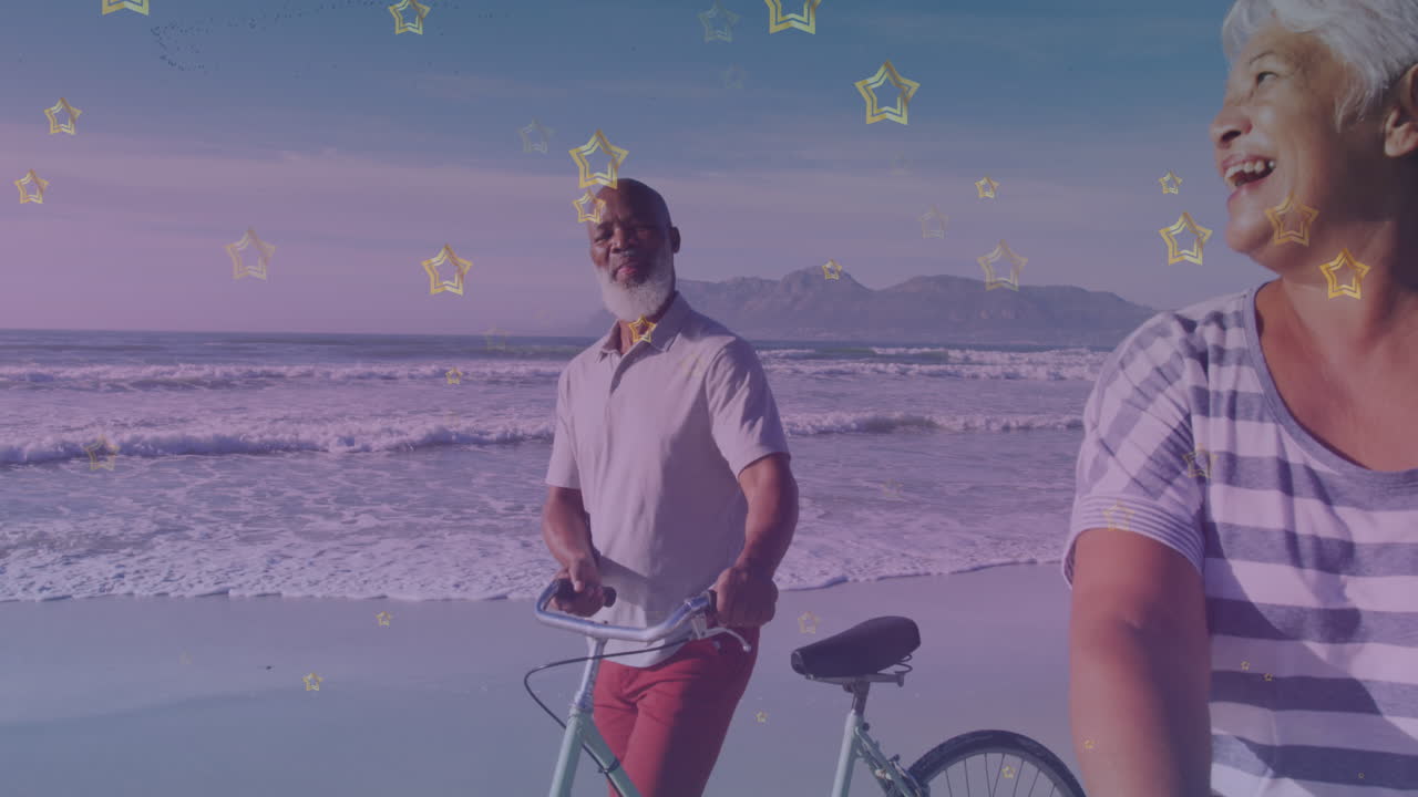 iconos de estrellas doradas contra una pareja mayor afroamericana con bicicleta caminando juntos en la playa