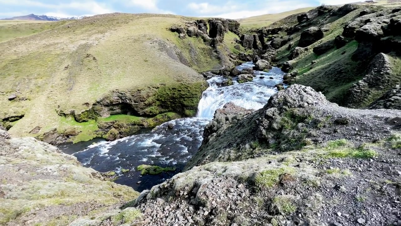 Islanda - Il filmato riprende un uomo che fa escursionismo tra i paesaggi mozzafiato del fiume Skógá in Islanda. Scopri il paesaggio meridionale dell'Islanda mentre scivoli attraverso i suoi panorami in questo video accattivante