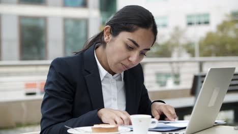 Mujer-De-Negocios-Usando-Laptop-Y-Trabajando-Con-Papeles