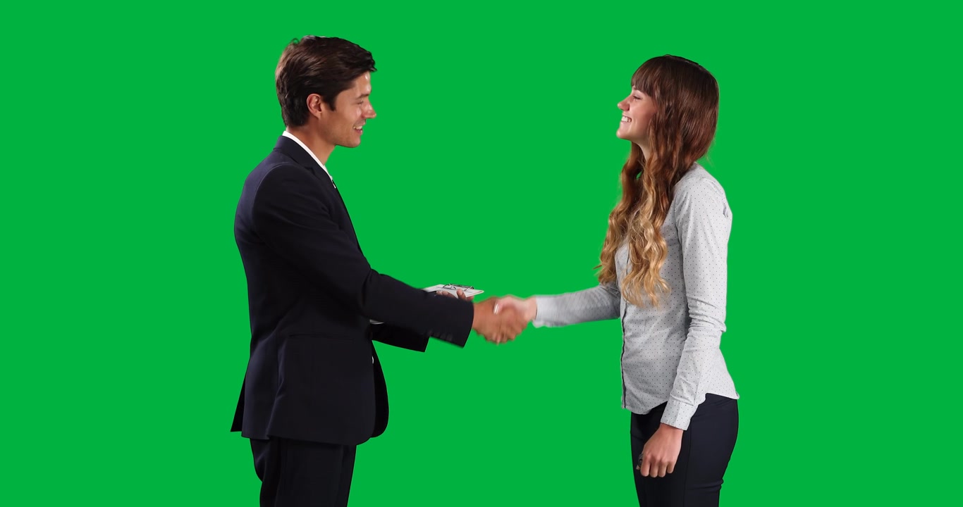 Uomo e donna d'affari che si stringono la mano su schermo verde