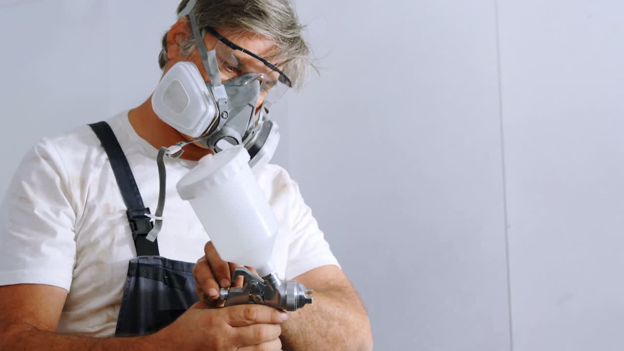 mecánico masculino comprobando la pintura en aerosol 4k