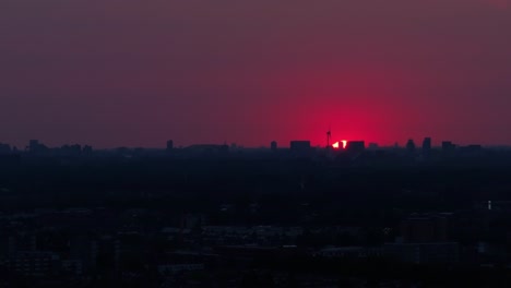 red skyline over a city and building silhouettes below