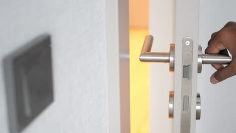 person opening a white door with a silver handle