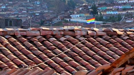 a flag of cusco peru flies over the down waving in the wind