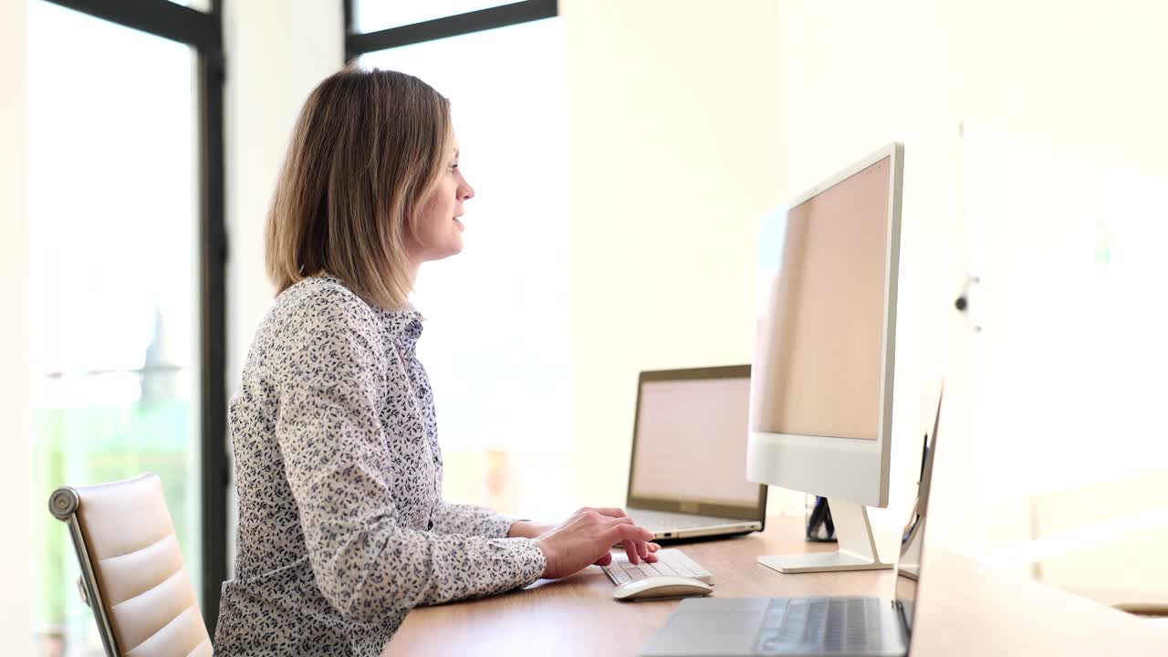 mujer trabajando en un escritorio con una computadora