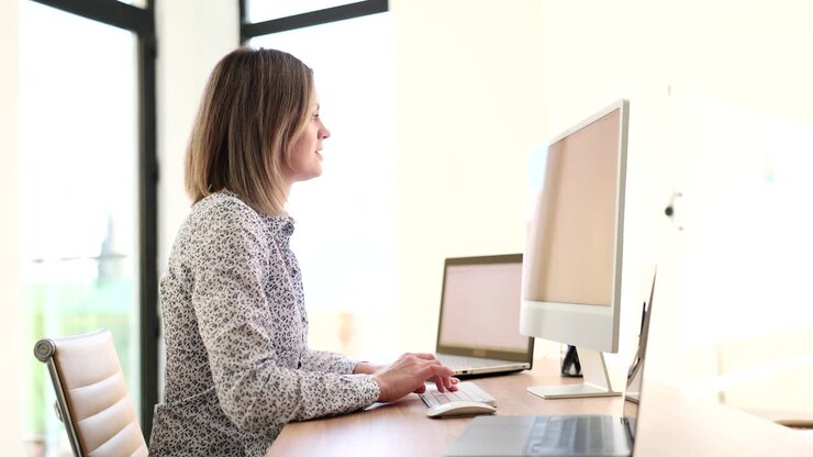 Kvinde arbejder ved skrivebord med computer