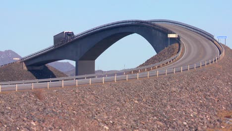 un camión viaja sobre un hermoso puente que cruza varias islas a lo largo de la carretera atlántica en noruega