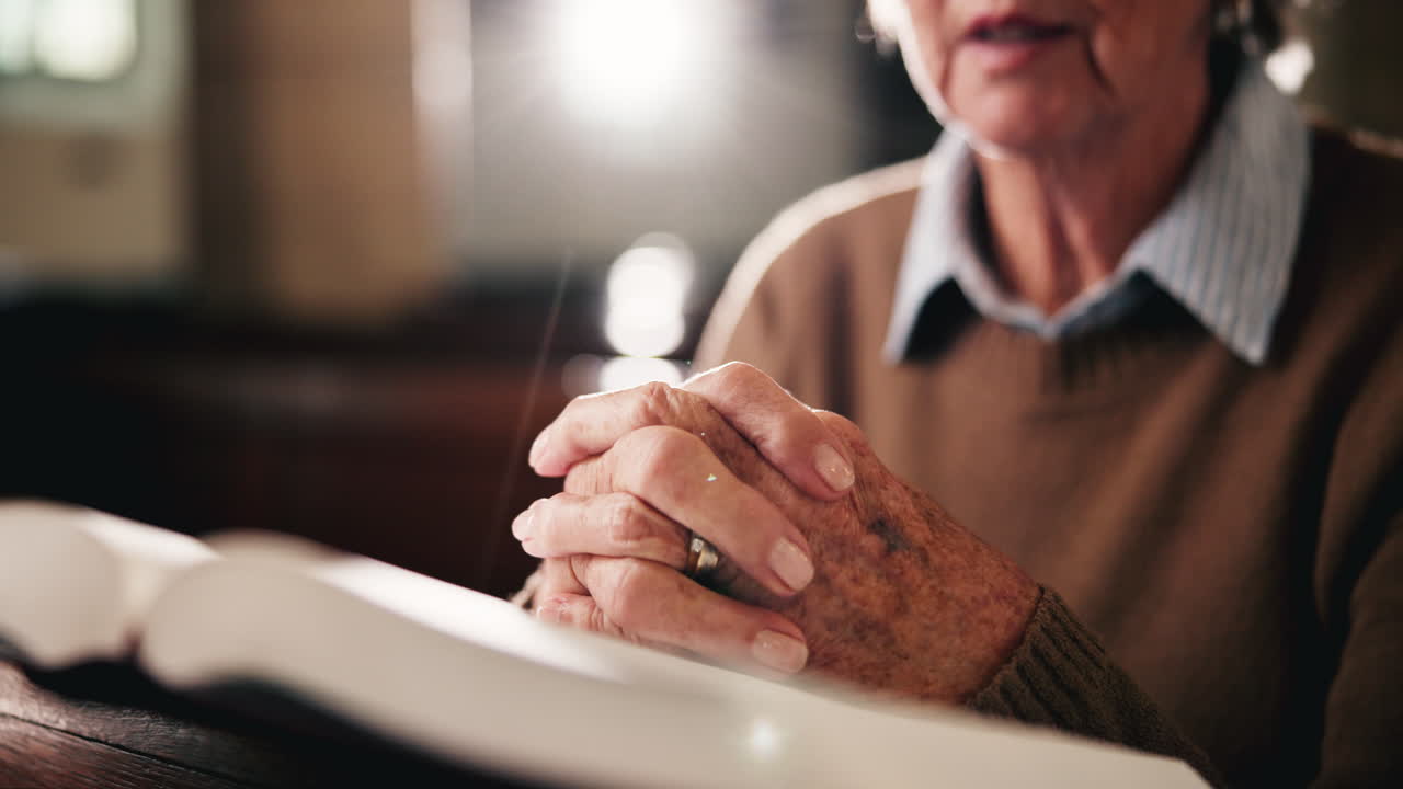 Senior woman praying in church with hands clasped